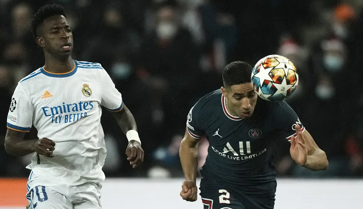 Penyerang Real Madrid Vinicius Junior berebut bola dengan bek Paris Saint Germain (PSG) Achraf Hakimi pada leg pertama babak 16 besar Liga Champions di Stadion Parc des Princes, Rabu dini hari WIB (16/2/2022). PSG susah payah kalahkan Real Madrid 1-0. (AP Photo/Thibault Camus)