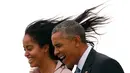 Rambut Malia Obama terbang terkena angin saat dirinya dan sang ayah yang juga Presiden AS, Barrack Obama turun dari pesawat Air Force One di Bandara O'Hare, Chicago, Kamis (7/4/2016). (REUTERS/Kevin Lamarque)