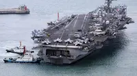 Kapal induk USS Carl Vinson dikawal ke pelabuhan angkatan laut di Busan, Korea Selatan, Minggu (2/3/2025). (Dok. Son Hyung-ju/Yonhap via AP)