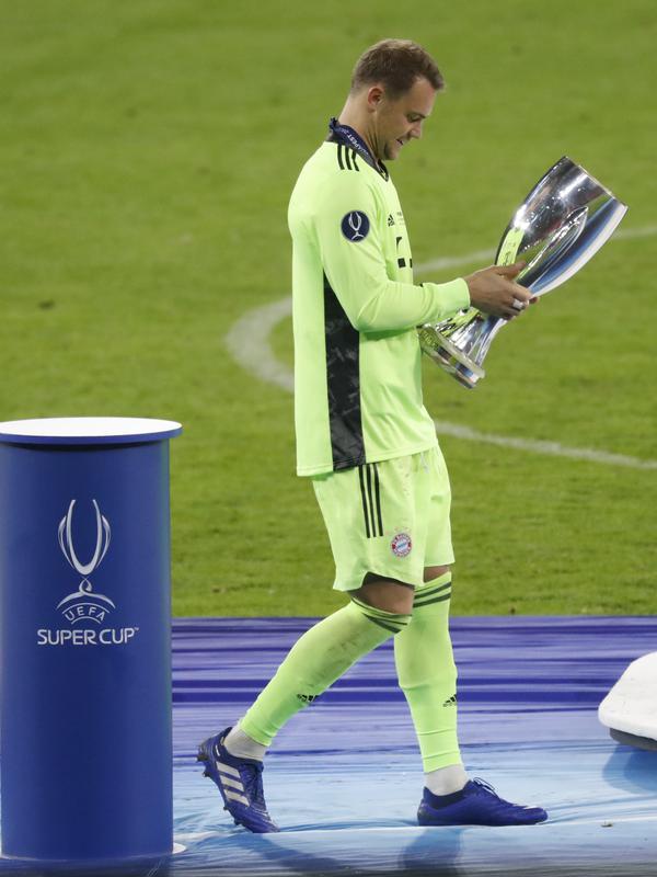 Kiper Bayern Munchen, Manuel Neuer memegang trofi usai pertandingan melawan Sevilla pada Piala Super Eropa di Budapest, Hongaria, Kamis (24/9/2020). Munchen menang tipis 2-1 atas Sevilla. (AP Photo/Bernadett Szabo)