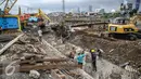 Para pekerja sedang memasangkan besi yang digunakan untuk pondasi dalam perbaikan jalan di kawasan Latumenten, Jakarta, Senin (05/12). (Liputan6.com/Faizal Fanani)