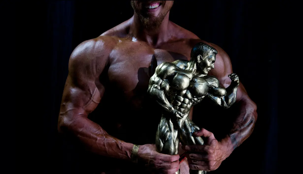 Foto pada 18 Oktober 2018, Or Magdasi dari Tel Aviv, memegang trofi setelah memenangkan kompetisi kontes binaraga amatir kategori pria di Israel. Magdasi berkesempatan mewakili Israel pada kompetisi Mr. Universe 2019 di Inggris. (AP/Oded Balilty)