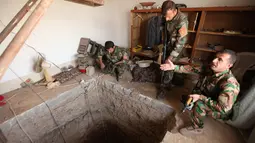 Tiga pasukan Peshmerga bersenjata memeriksa terowongan tempat persembunyian militan ISIS selama operasi penyerangan di Mosul, Irak (19/10). Operasi pengepungan oleh pasukan koalisi Irak untuk mengepung para militan ISIS. (REUTERS/Azad Lashkari)