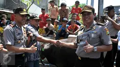 Inspektur Pengawas Daerah Kombes Polda Metro Jaya Didit Prabowo (kanan) bersama Kepala Polisi Resort Jakarta Pusat Hendro Pandowo (kiri) menyerahkan dua ekor sapi kurban di kawasan Johar Baru, Jakarta, Rabu (23/9/2015). (Liputan6.com/Gempur M Surya)