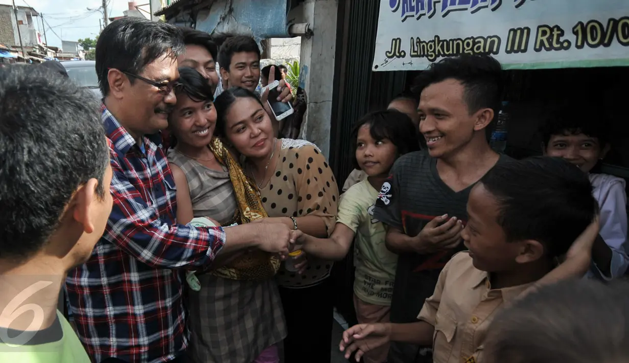 Cawagub DKI Jakarta, Djarot Saiful Hidayat bersalaman dengan warga Tegal Alur, Jakarta, Rabu (7/12). Dalam blusukannya Djarot berjanji akan segera memasukkan pelayanan air perpipaan di permukiman warga Tegal Alur. (Liputan6.com/Yoppy Renato)