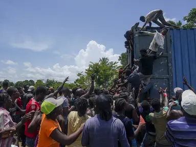 Warga naik ke truk yang penuh dengan pasokan bantuan untuk korban gempa, di Vey Terre, Haiti, Jumat (20/8/2021). Bantuan swasta dan kiriman dari pemerintah AS dan lainnya tiba di semenanjung barat daya negara itu yang dilanda gempa 7,2 gempa berkekuatan 14 Agustus. (AP Photo/Fernando Llano)