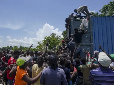 Warga naik ke truk yang penuh dengan pasokan bantuan untuk korban gempa, di Vey Terre, Haiti, Jumat (20/8/2021). Bantuan swasta dan kiriman dari pemerintah AS dan lainnya tiba di semenanjung barat daya negara itu yang dilanda gempa 7,2 gempa berkekuatan 14 Agustus. (AP Photo/Fernando Llano)