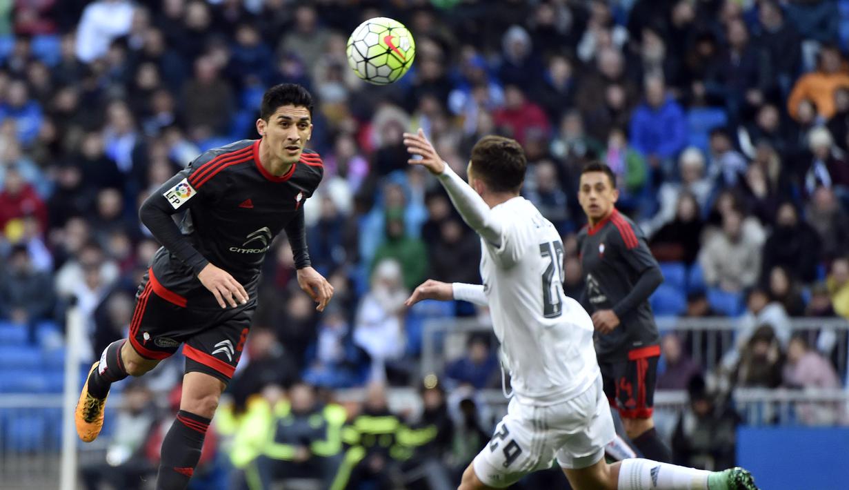 Pemain Celta Vigo, Hernandez (kiri) berebut bola dengan pemain Real Madrid,  Mayoral pada lanjutan La Liga Spanyol di Stadion Santiago Bernabeu , Madrid, Sabtu (5/3/2016). (AFP/Gerard Julien)