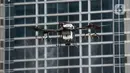 Drone menyemprotkan cairan disinfektan di Jalan Bursa Efek menuju Patung  Pemuda, Jakarta, Jumat (27/3/2020). Penyemprotan dilakukan untuk mencegah penyebaran virus corona COVID-19. (merdeka.com/Imam Buhori)