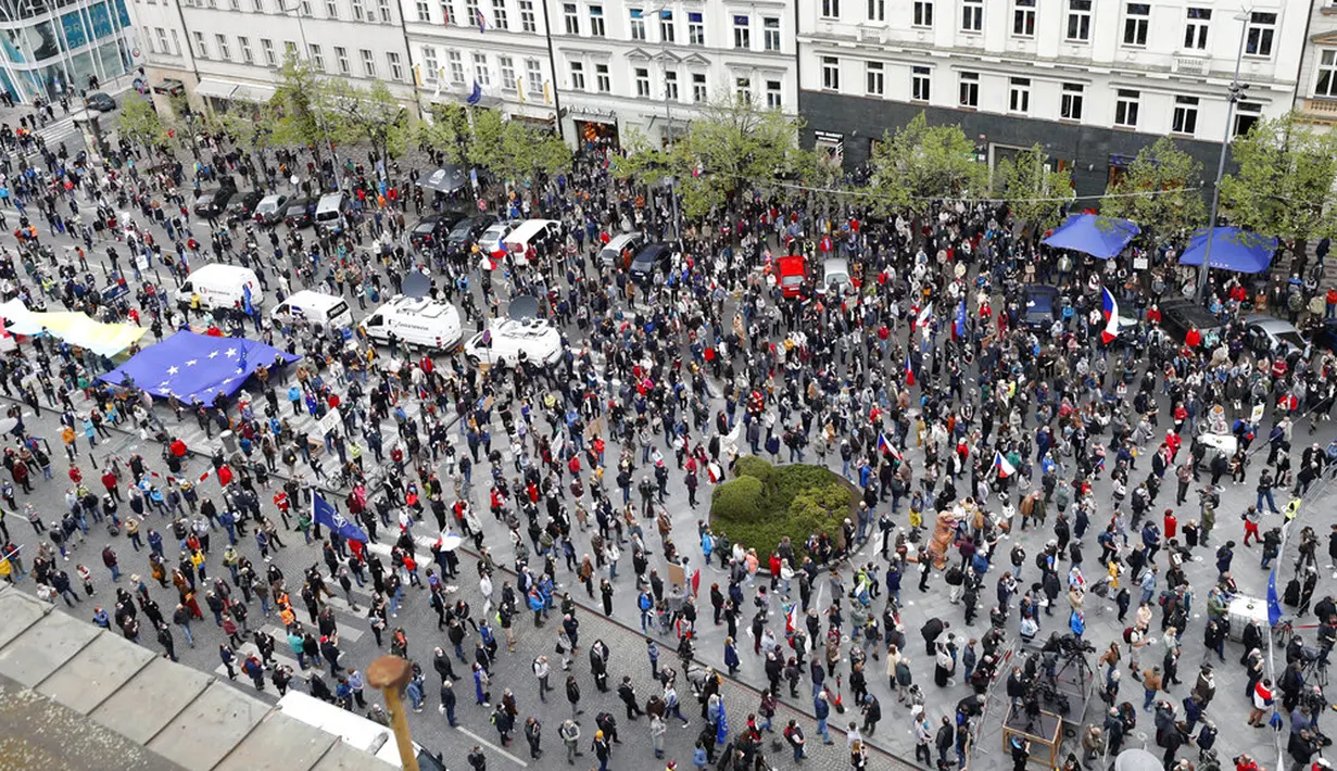 Warga berusaha jaga jarak saat berdemonstrasi di Praha, Republik Ceko, Kamis (29/4/2021). Ribuan warga berunjuk rasa menentang Presiden Milos Zeman dan menuduhnya melakukan pengkhianatan atas sikap pro Rusia pada dugaan partisipasi mata-mata Rusia dalam ledakan di Ceko. (AP Photo/Petr David Josek)