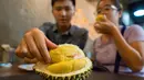 Pengunjung memakan durian di kafe Mao Shan Wang di Singapura (26/1). Restoran yang menyediakan beragam aneka rasa durian ini telah menarik banyak pengunjung untuk datang mencicipi buah durian di kafe tersebut. (AFP Photo/Nicholas Yeo)