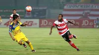 Pemain Madura United, Engelberd Sani (kanan) mencoba melewati hadangan pemain Persiba Balikpapan pada laga Torabika SC 2016 di Stadion Gelora Bangkalan, Senin(13/6/2016).  (Bola.com/Nicklas Hanoatubun)