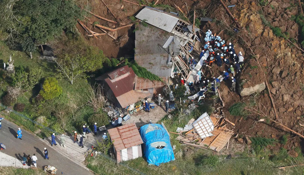 Petugas penyelamat dan polisi berusaha mencari korban usai terjadi longsor yang menghantam rumah hunian di Nakatsu, Prefektur Oita, Jepang (11/4). Longsor ini melanda kawasan pegunungan di kota Yabakei, wilayah Nakatsu. (Takuto Kaneko/Kyodo News via AP)
