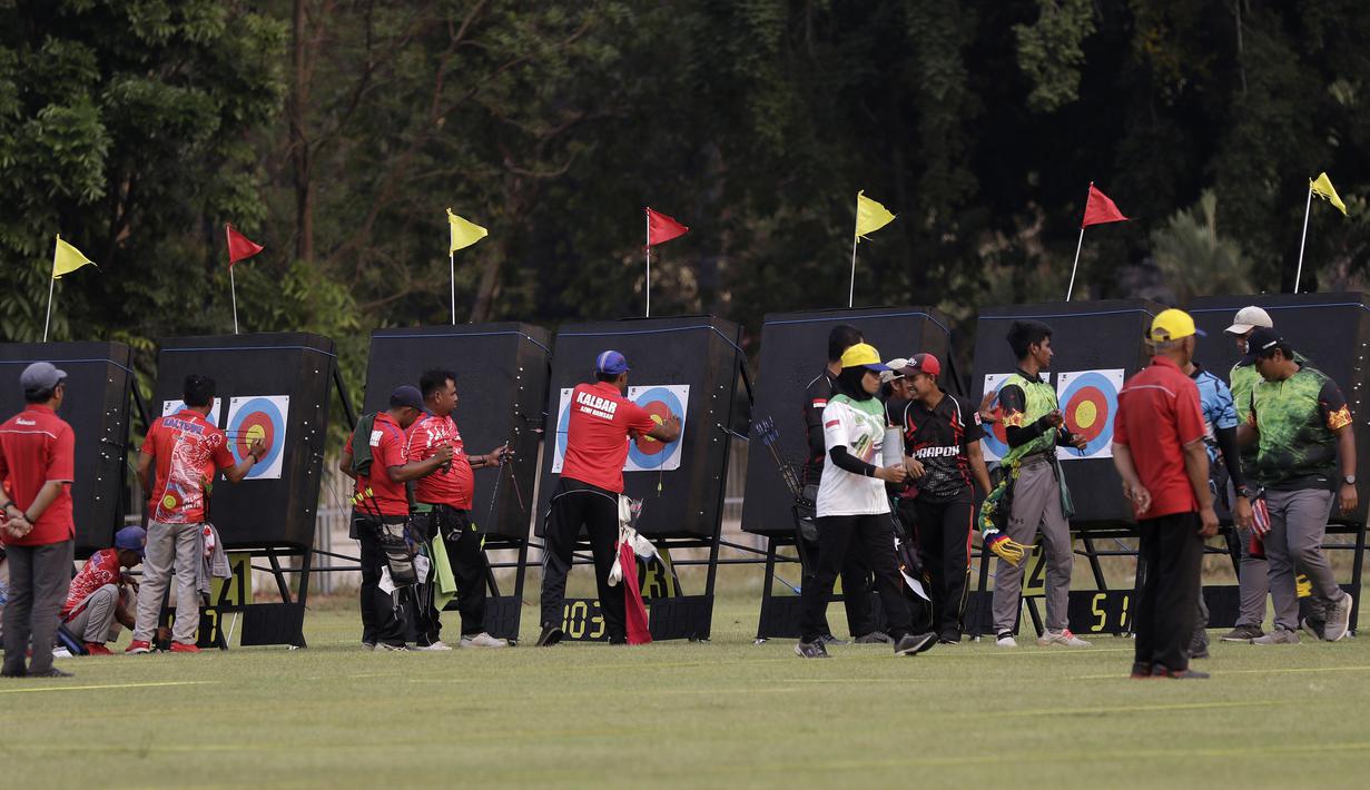 Pepanah compound beregu putra melihat nilai sasaran saat Kejuaraan Nasional Panahan Prakualifikasi PON XX/2020 di Lapangan Panahan, Senayan, Jakarta, Selasa (24/9). Sebanyak 516 pepanah dari 30 provinsi bersaing untuk bisa lolos ke PON 2020 Papua. (Bola.com/Yoppy Renato)
