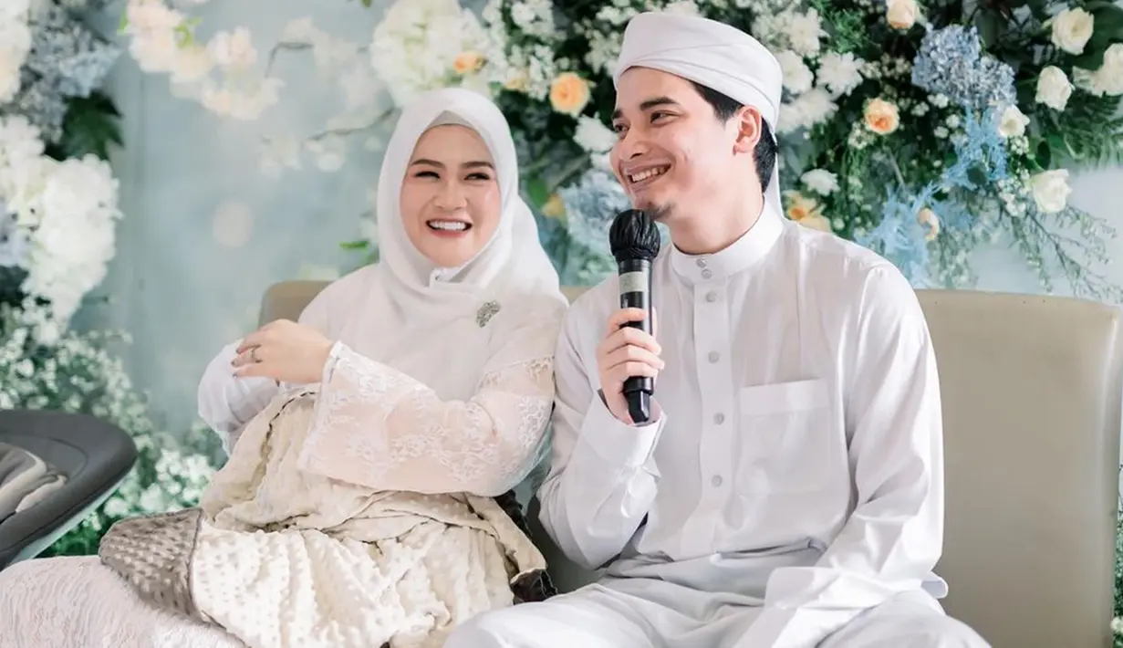Alvin Faiz dan Henny Rahman mengadakan acara akikah untuk buah hati pertamanya, pada Kamis (30/3/2023). Pasangan tersebut tampak begitu serasi dengan busana putih. Tak hanya itu, dekorasi acara akikah tampak mewah dengan nuansa biru. (Liputan6.com/IG/@malycaphoto)