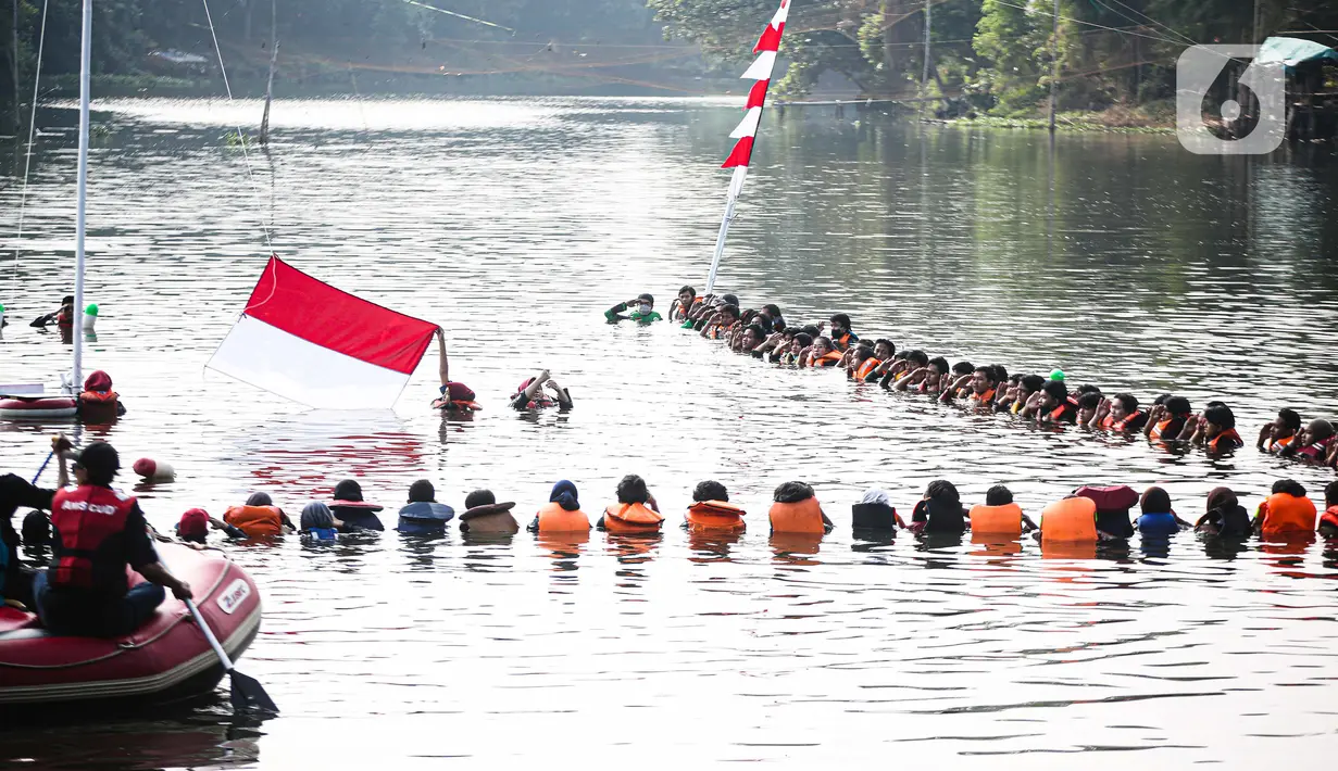 Petugas mengibarkan bendera saat Upacara Peringatan HUT ke-75 RI di Situ Tujuh Muara Pamulang, Tangsel, Senin (17/8/2020). Upacara yang diikuti ratusan aktivis lingkungan hidup dan juga organisasi kepemudaan itu bertujuan agar pemerintah terus menjaga keberadaan situ. (Liputan6.com/Faizal Fanani)