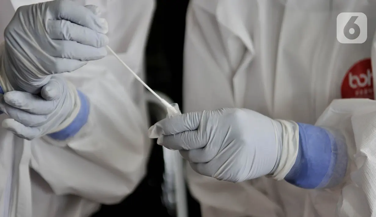 Petugas medis memasukkan hasil tes swab salah satu pedagang ke dalam tabung di Pasar Kramat Jati, Jakarta, Rabu (17/6/2020). Ratusan pedagang Pasar Kramat Jati menjalani tes swab secara bertahap sebagai upaya pemerintah memutus rantai penyebaran virus Covid-19. (merdeka.com/Iqbal S. Nugroho)