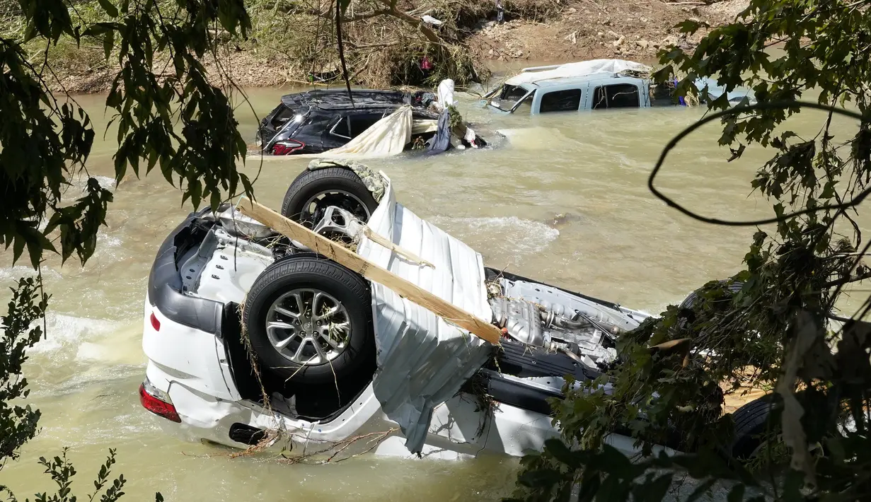 Kendaraan yang terbawa arus banjir berhenti di sungai di Waverly, Tennessee, Minggu (22/8/2021). Banjir parah yang melanda Middle Tennessee, AS, menyebabkan sedikitnya 22 orang tewas, sementara sekitar 50 orang lainnya dilaporkan masih hilang. (AP Photo/Mark Humphrey)