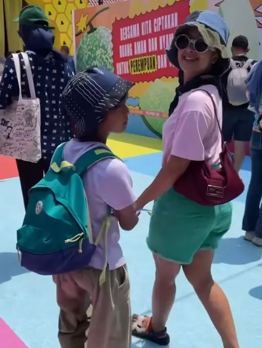 <p>Widi Mulia tampil dengan atasan t shirt pink dipadukan syal hitam serta short pants hijau. Ia membawa shoulder bag maroon dan mengenakan kacamata hitam model bulat. Tak lupa bucket hatnya. [@widimulia]</p>