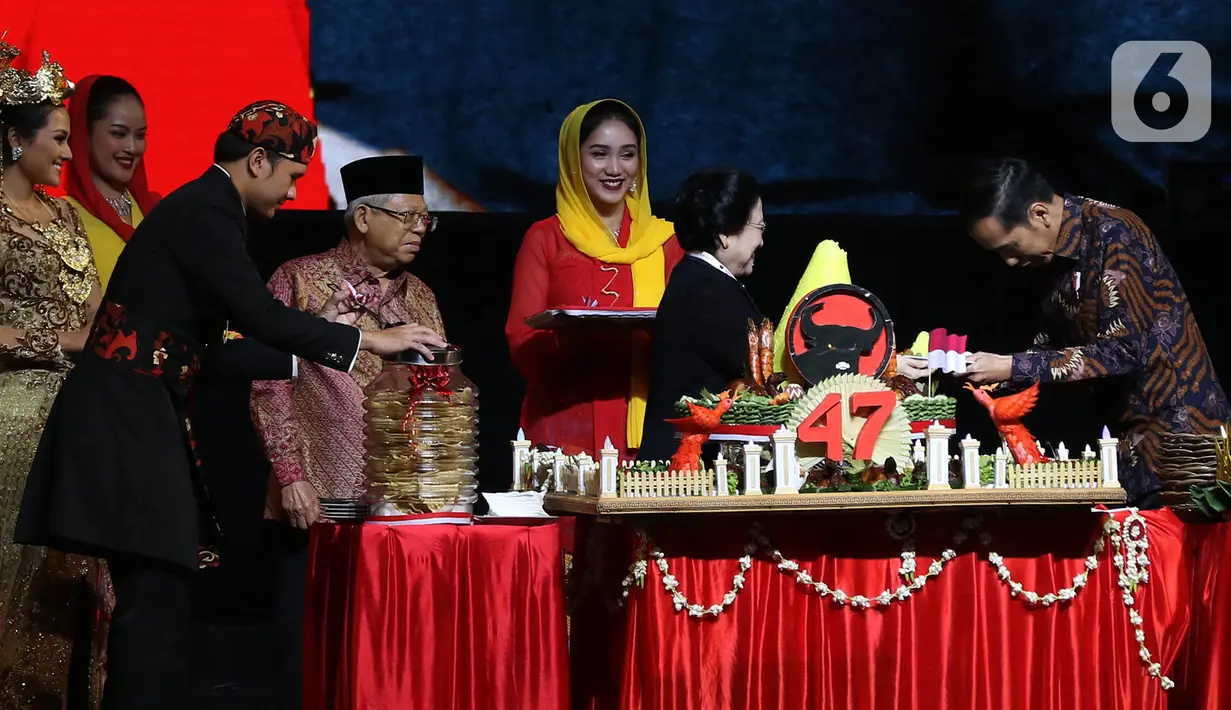 Ketua Umum PDI Perjuangan Megawati Soekarnoputri (kedua kanan) menyerahkan potongan tumpeng kepada Presiden Joko Widodo disaksikan Wakil Presiden Ma'ruf Amin (keempat kiri) saat pembukaan Rakernas I dan HUT ke-47 PDIP di JIEXPO Kemayoran, Jakarta, Jumat (10/1/2020). (Liputan6.com/Johan Tallo)