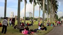 Sejumlah pengunjung beristirahat di taman yang berada di kawasan Monumen Nasional (Monas), Jakarta, Rabu (27/6). Libur ketiga Lebaran dimanfaatkan warga untuk bekunjung ke lokasi wisata bersama keluarga. (Liputan6.com/Johan Tallo)