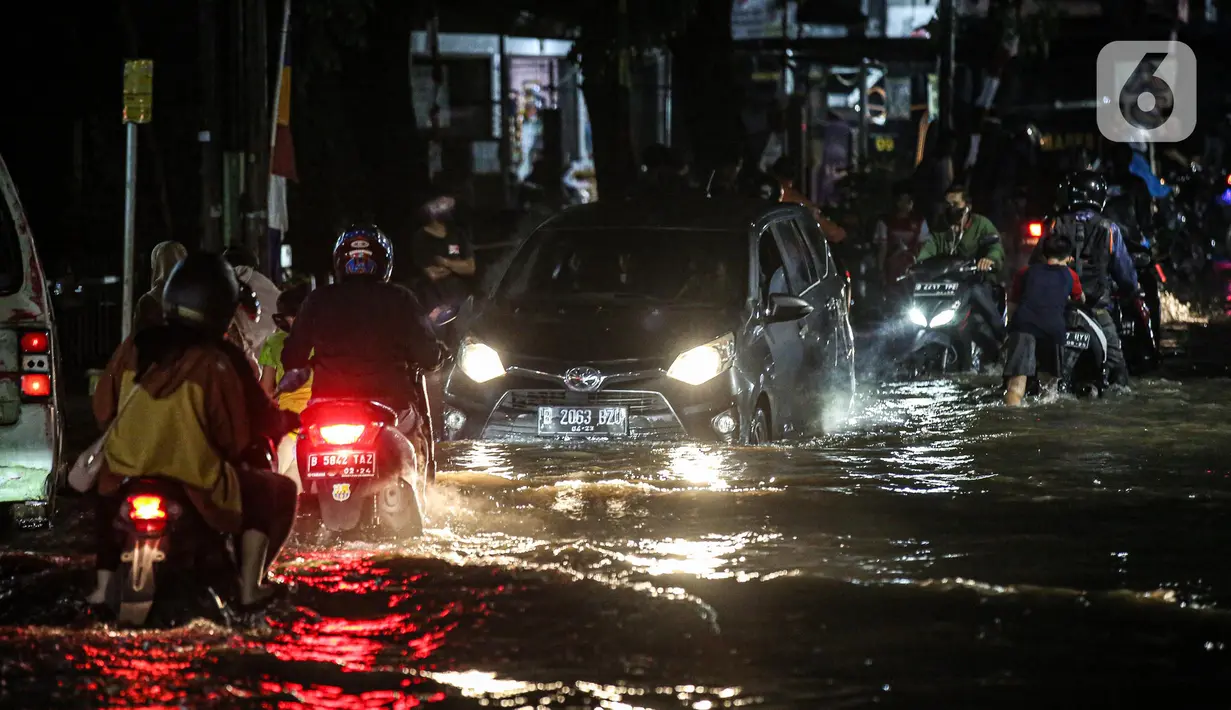 Sejumlah kendaraan menerjang banjir di Jalan Ciracas Raya, Jakarta, Jumat (12/8/2022). Hujan lebat yang terjadi sore tadi membuat Jalan Ciracas Raya tergenang air dan kendaraan terjebak banjir. (Liputan6.com/Faizal Fanani)