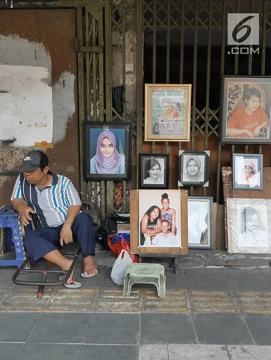Seorang pelukis menunggu calon pemesan di trotoar Kawasan Glodok, Jakarta, Selasa (15/5). Bagi warga yang ingin dilukis, biasanya harus menyerahkan foto sebagai contoh materi lukisan. (Liputan6.com/Herman Zakharia)