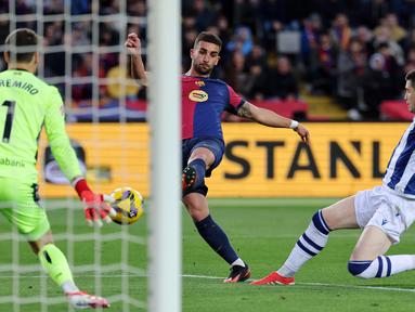 Penyerang Barcelona, Ferran Torres (tengah) melakukan tendangan ke arah gawang Real Sociedad pada laga pekan ke-26 Liga Spanyol 2024/2025 di Estadi Olimpic Lluis Companys, Minggu 2 Maret 2025 malam WIB. (LLUIS GENE/AFP)
