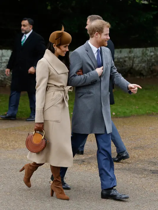 Pangeran Harry dan sang tunangan, Meghan Markle menghadiri tradisi pelayanan gereja di hari Natal Kerajaan Inggris di Sandringham, Senin (25/12). Meghan tampil cantik dengan coat krem, dipadukan tas, topi, dan kaos tangan serba coklat. (AP/Alastair Grant)