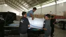 Petugas menurunkan bantuan 4 tenda darurat dan kebutuhan lainnya dari PT Jakarta International Container Terminal (JICT) untuk korban gempa dan tsunami di Palu dan Donggala di Gudang IHC-ACT Parung, Bogor, Jumat (12/10). (Liputan6.com/HO/Arif)