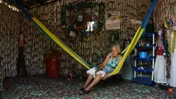 Maria Ponce (86) duduk di atas ayunan di Desa El Borbollon, El Transito, San Salvador, El Salvador 14 Maret 2017. Karena tak memiliki cukup uang nenek ini mendirikan rumah dengan menggunakan botol plastik. (AFP Photo/Marvin Recinos)