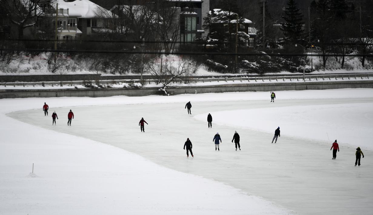 Orang-orang menyusuri Rideau Canal Skateway pada hari pembukaannya di Ottawa, Ontario, Kamis (28/1/2021). Karena pandemi, tempat konsesi, penyewaan skate dan fasilitas ganti di sepanjang skateway akan tetap ditutup, dan tidak akan ada meja piknik musim ini. (Justin Tang/The Canadian Press via AP)