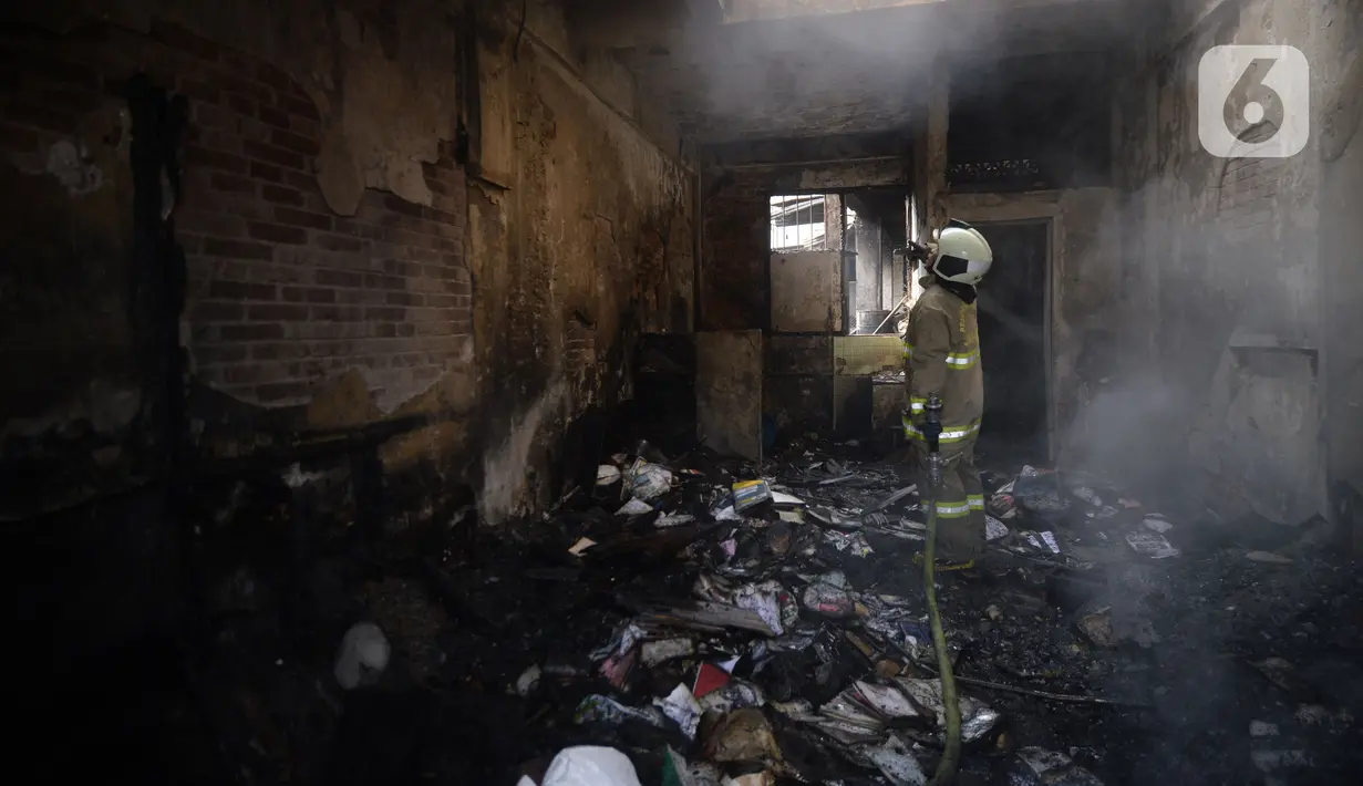 Petugas pemadam kebakaran melakukan pembasahan bioskop Grand Theater yang terbakar di Simpang Lima Senen, Jakarta, Jumat (9/10/2020). Unjuk rasa menentang disahkannya Omnibus Law UU Cipta Kerja berujung aksi anarkis merusak berbagai fasilitas umum pada Kamis malam (8/10). (merdeka.com/Dwi Narwoko)
