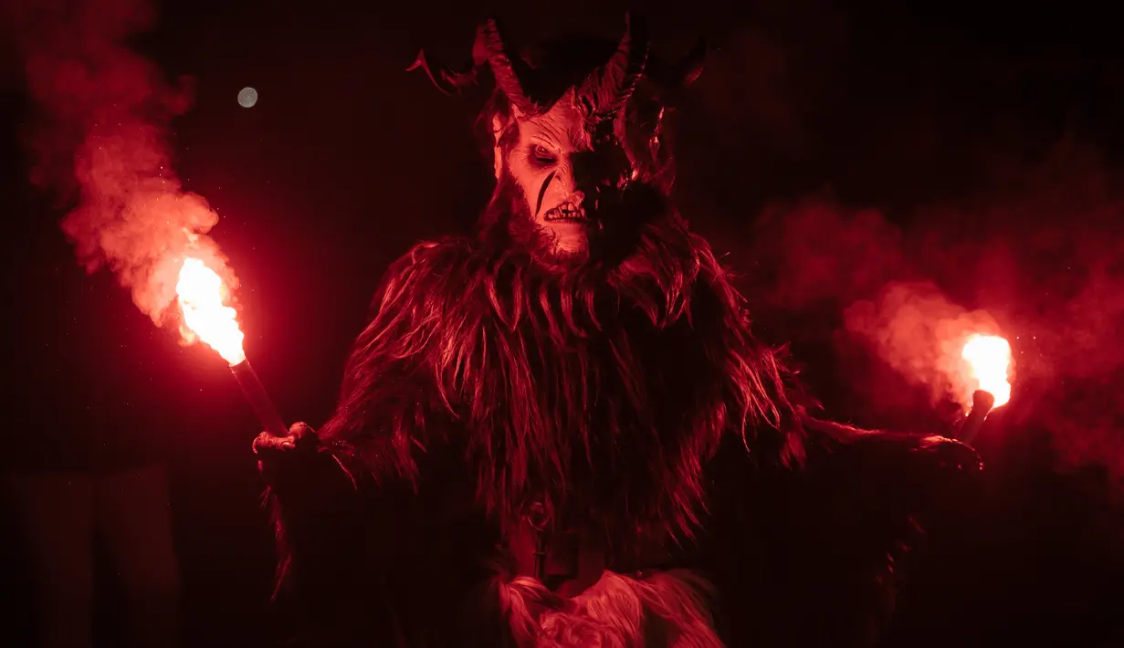 Partisipan berpakaian seperti Krampus, makhluk setengah iblis, saat ambil bagian dalam parade di kota Podkoren, Slovenia, Jumat (30/11). Tradisi natal ini juga dilakukan di beberapa negara seperti Austria, Jerman, Hungaria dan Ceko. (Jure Makovec/AFP)