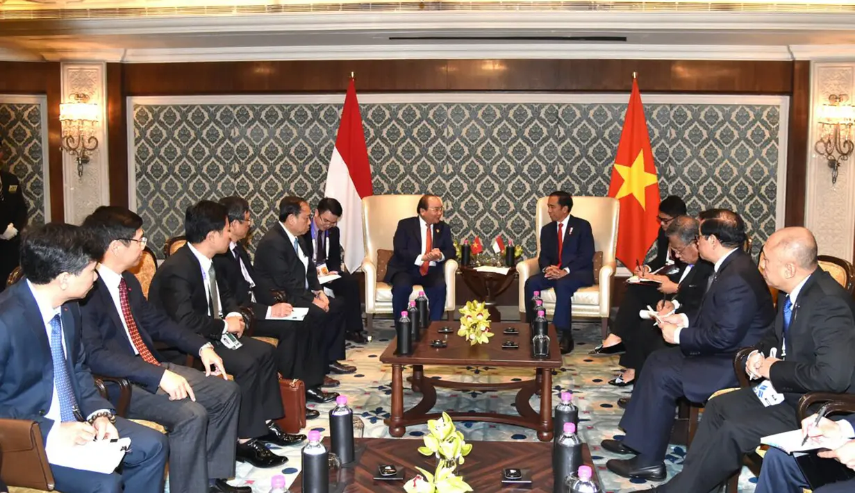 Presiden Jokowi dan PM Vietnam, Nguyen Xuan Phuc berbincang saat pertemuan bilateral disela KTT ASEAN-India di New Delhi, Jumat (26/1). Pertemuan kedua kepala negera tersebut didampingi menteri masing-masing. (Liputan6.com/Pool/Biro Pers Setpres)