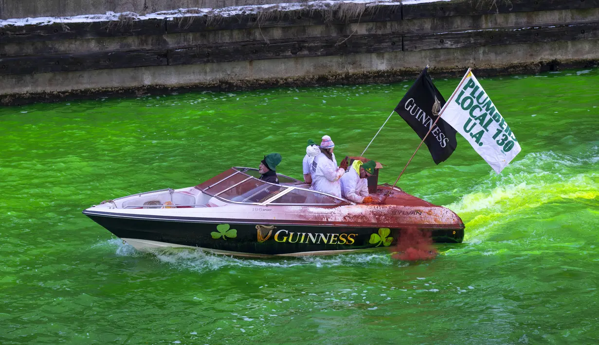 Anggota Plumbers Union Local 130 mewarnai Sungai Chicago dengan warna hijau, Sabtu (12/3/2022). Perubahan warna ini dilakukan untuk menyambut Hari St. Patrick pada Kamis mendatang. (Tyler Pasciak LaRiviere/Chicago Sun-Times via AP)