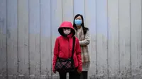 Pejalan kaki mengenakan sungkup muka untuk melindungi diri dari wabah virus corona saat bersiap menyeberang jalan di Hong Kong pada 4 Februari 2020. WHO mengatakan wabah virus corona COVID-19 merupakan ancaman sangat besar bagi seluruh dunia. (Anthony WALLACE/AFP)