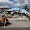 Sebuah sepeda motor berhenti di dekat bangunan yang runtuh pascagempa berkekuatan magnitudo 7,7 di Borong, Manggarai Timur, Nusa Tenggara Timur, Minggu, 16 Agustus 2026.. (AFP/ Juni Kriswanto)