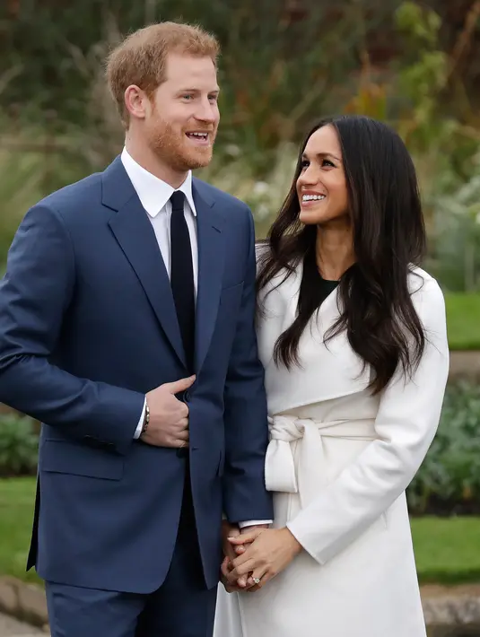 Pangeran Harry dan aktris AS, Meghan Markle saling bergenggaman saat mengumumkan pertunangan mereka di Kensington Palace, London, Senin (27/11). Nantinya, Harry dan Markle akan tinggal di Nottingham Cottage di kawasan istana Kensington. (AP/Matt Dunham)