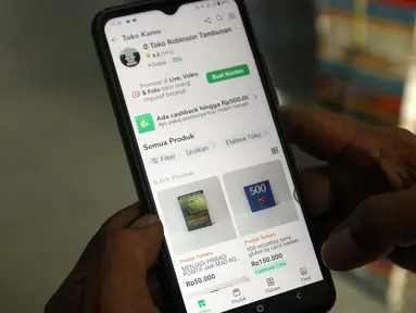 Pedagang buku sentra buku pasar Kenari sedang mengecek status penjualan buku di salah satu platform marketplace, Jakarta, Selasa (30/1/2024). (Liputan6.com/Herman Zakharia)