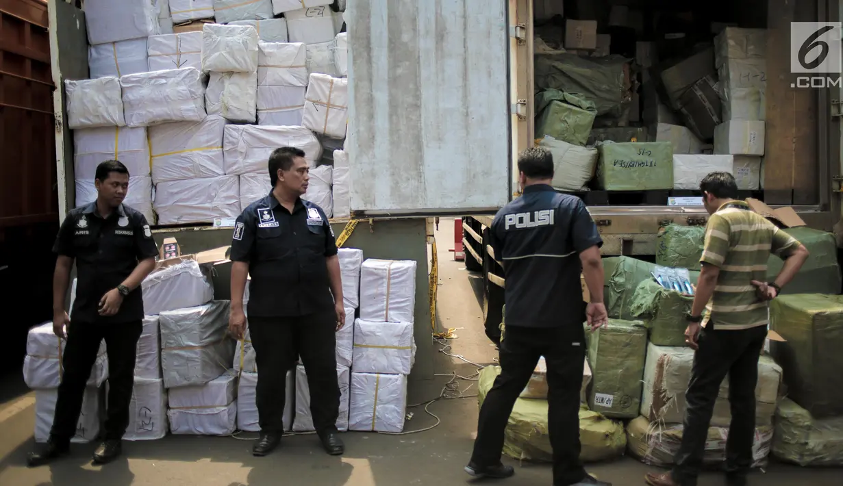 Petugas Subdit I Reskrimsus Polda Metro Jaya (PMJ) menunjukkan barang bukti saat rilis kasus penyelundupan barang ilegal di Halaman Ditreskrimsus Polda Metro Jaya, Rabu (14/8/2019). Polisi mengamankan 11 truk berisi kosmetik, obat-obattan dan barang ilegal lainnya. (Liputan6.com/Faizal Fanani)