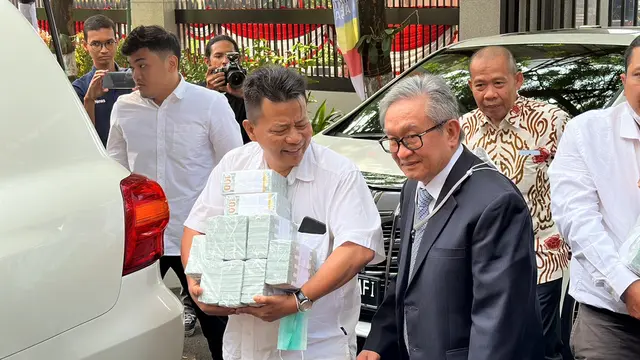 Kuasa Hukum Irwan Hermawan, Maqdir Ismail mendatangi Kejagung dengan membawa uang senilai Rp27 miliar.