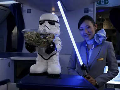 Seorang Pramugari menyapa pengunjung sambil memegang lightsabre atau pedang laser di pesawat Boeing 787 Dreamliner, Singapura, Kamis (12/11/2015).  Pesawat bertema Star Wars ini menjadi pertama di Asia Tenggara. (REUTERS/Edgar Su)