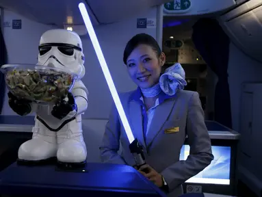 Seorang Pramugari menyapa pengunjung sambil memegang lightsabre atau pedang laser di pesawat Boeing 787 Dreamliner, Singapura, Kamis (12/11/2015).  Pesawat bertema Star Wars ini menjadi pertama di Asia Tenggara. (REUTERS/Edgar Su)