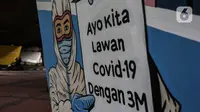 Mural imbauan untuk melawan COVID-19 terlihat di bawah kolong jembatan di Jakarta, Kamis (17/11/2020). Pemerintah Klaim Tingkat Kesembuhan Pasien Covid-19 Indonesia di Atas Global. (Liputan6.com/JohanTallo)