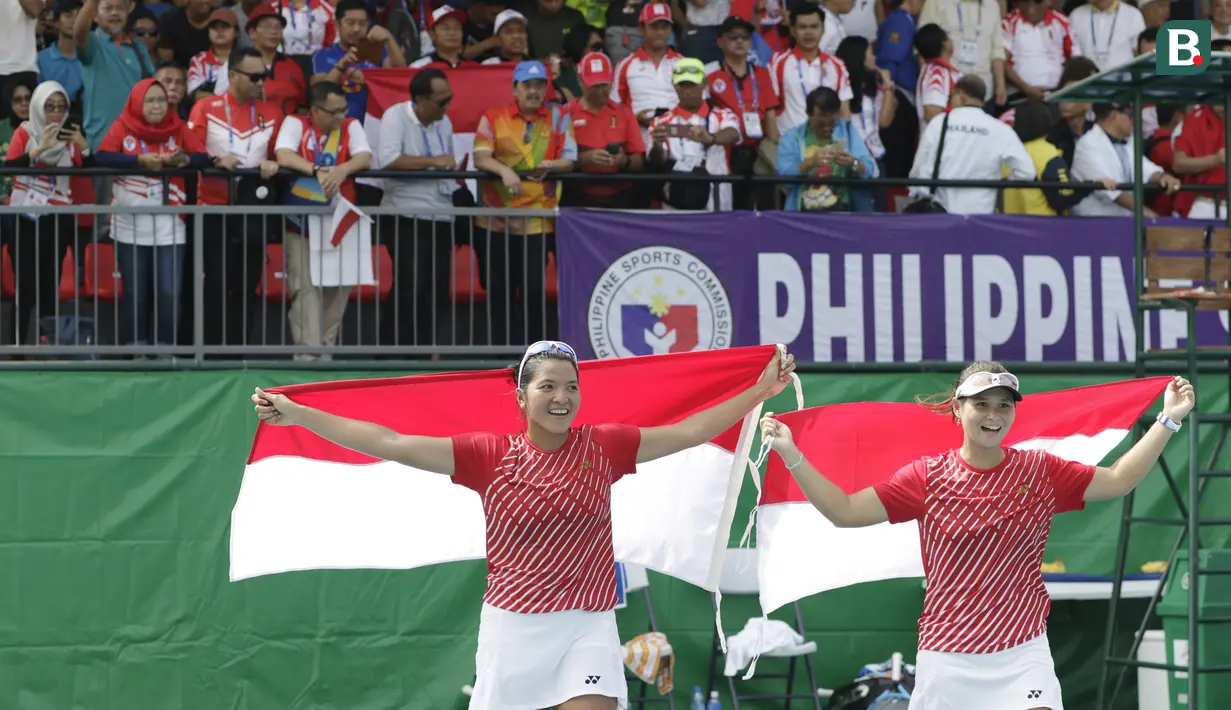 Ganda putri Indonesia, Beatrice Gumulya / Jessie Rompies, merayakan gelar juara usai mengalahkan wakil Thailand pada laga final SEA Games 2019 di Tennis Court Rizal Memorial Sports Complex, Manila Sabtu (7/12). Indonesia menang dengan skor 6-3 dan 6-3. (Bola.com/ M Iqbal Ichsan)