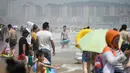 Orang-orang mengunjungi pantai sambil mendinginkan diri di Qingdao, China timur, pada 3 Agustus 2019. Banyak warga di Negeri Tirai Bambu memanfaatkan musim panas dengan mengunjungi pantai untuk mengisi liburan. (Photo by FRED DUFOUR / AFP)