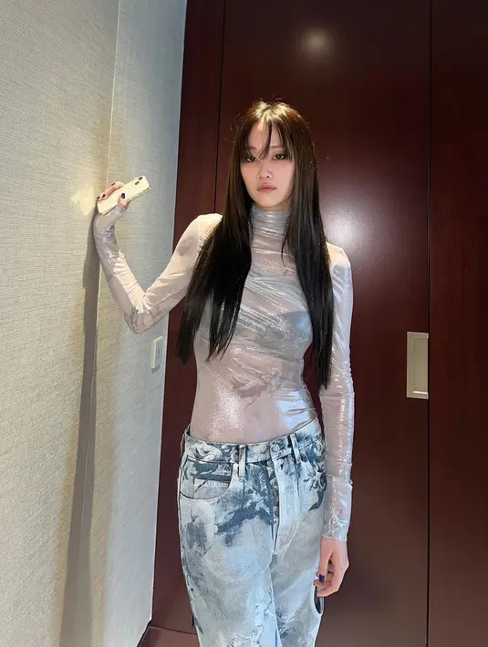 Potret penuh pesona Jeon Jong Seo saat menjalani photoshoot. Ia mengenakan atasan lengan panjang berkerah tinggi berwarna silver yang semi transparan menampilkan bra hitam yang dikenakannya, dipadu celana panjang jeans serasi. [Foto: Instagram/wjswhdtj94]