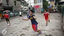 Ekspresi salah satu remaja saat bermain sepak bola di kolong rel kereta kawasan Juanda, Jakarta, Jumat (27/5). Tidak tersedianya ruang terbuka menyebabkan lahan tersebut dijadikan tempat bersosialisasi bagi warga. (Liputan6.com/Immanuel Antonius)