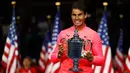 Petenis Spanyol, Rafael Nadal memegang trofi AS Terbuka 2017 setelah mengalahkan petenis Afrika Selatan, Kevin Anderson di New York, Minggu (10/9). Bagi Nadal, ini adalah gelar ketiganya di AS Terbuka setelah 2010 dan 2013. (AP Photo/Julio Cortez)